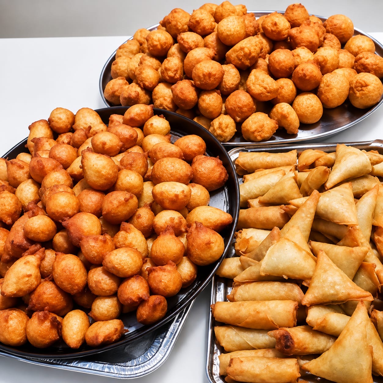 TeshTreats party tray with puff puff, samosas, and spring rolls